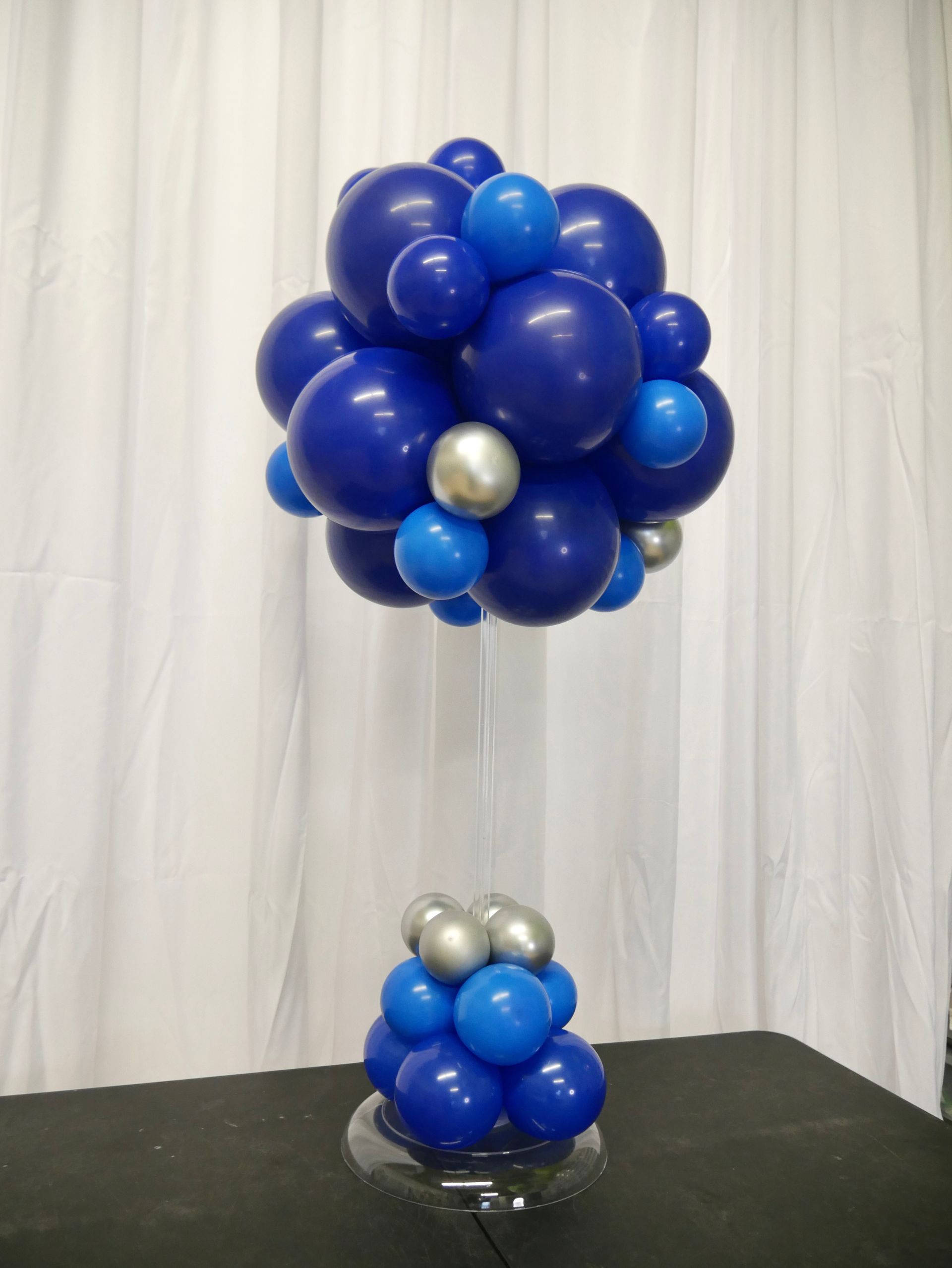 A bunch of blue and silver balloons on a table