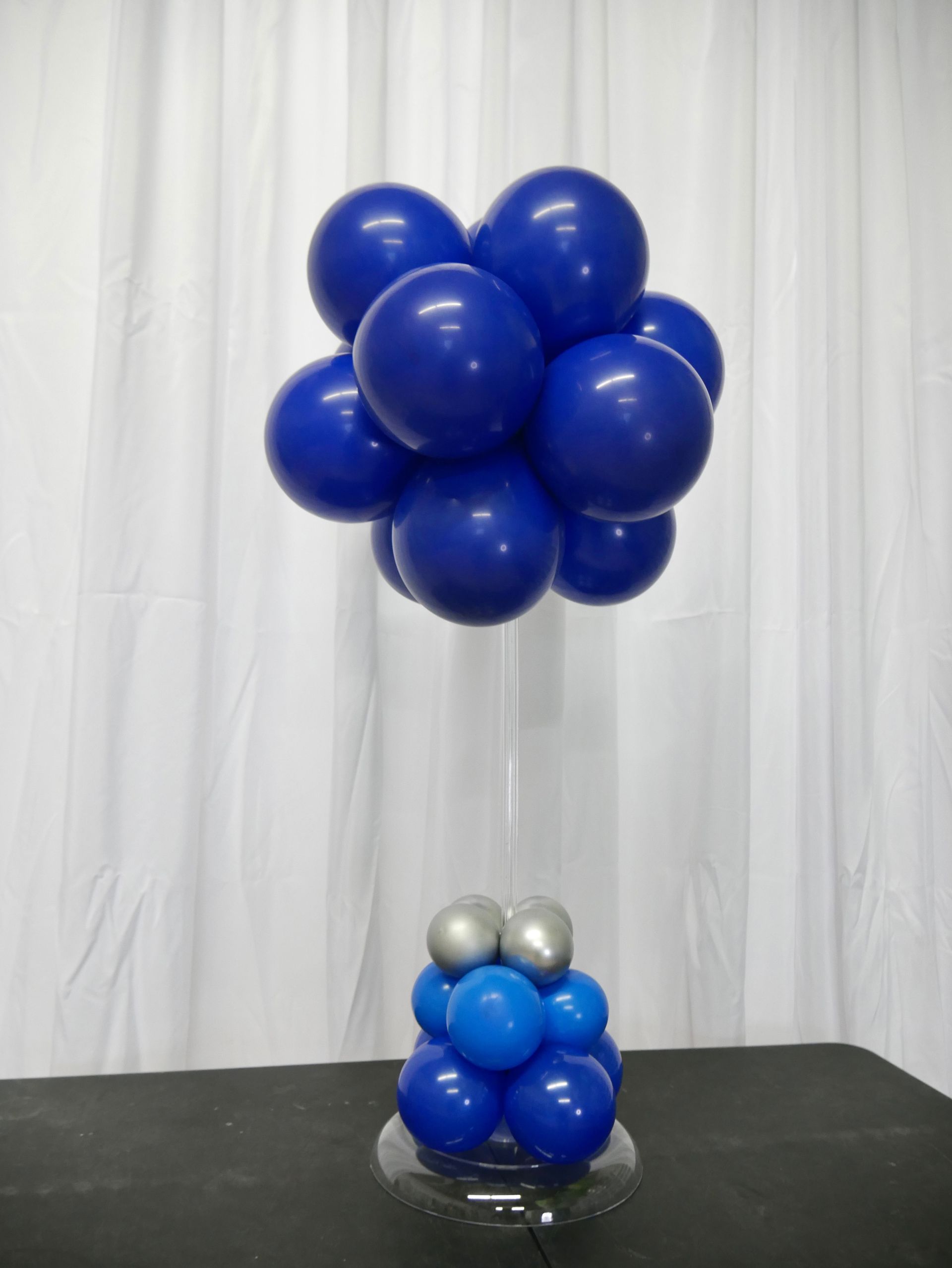 A bunch of blue balloons in a vase on a table