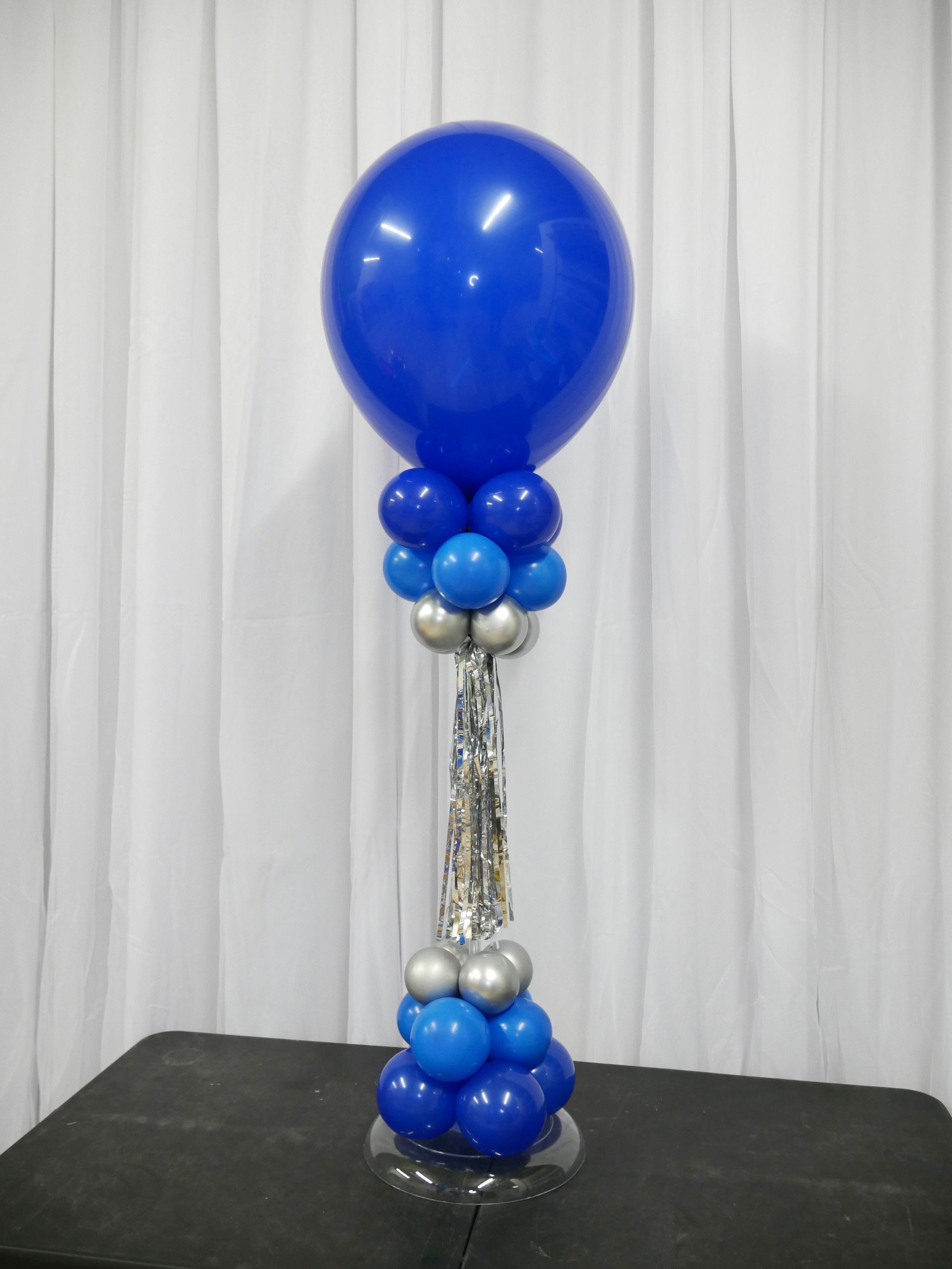 A blue and silver balloon display on a table