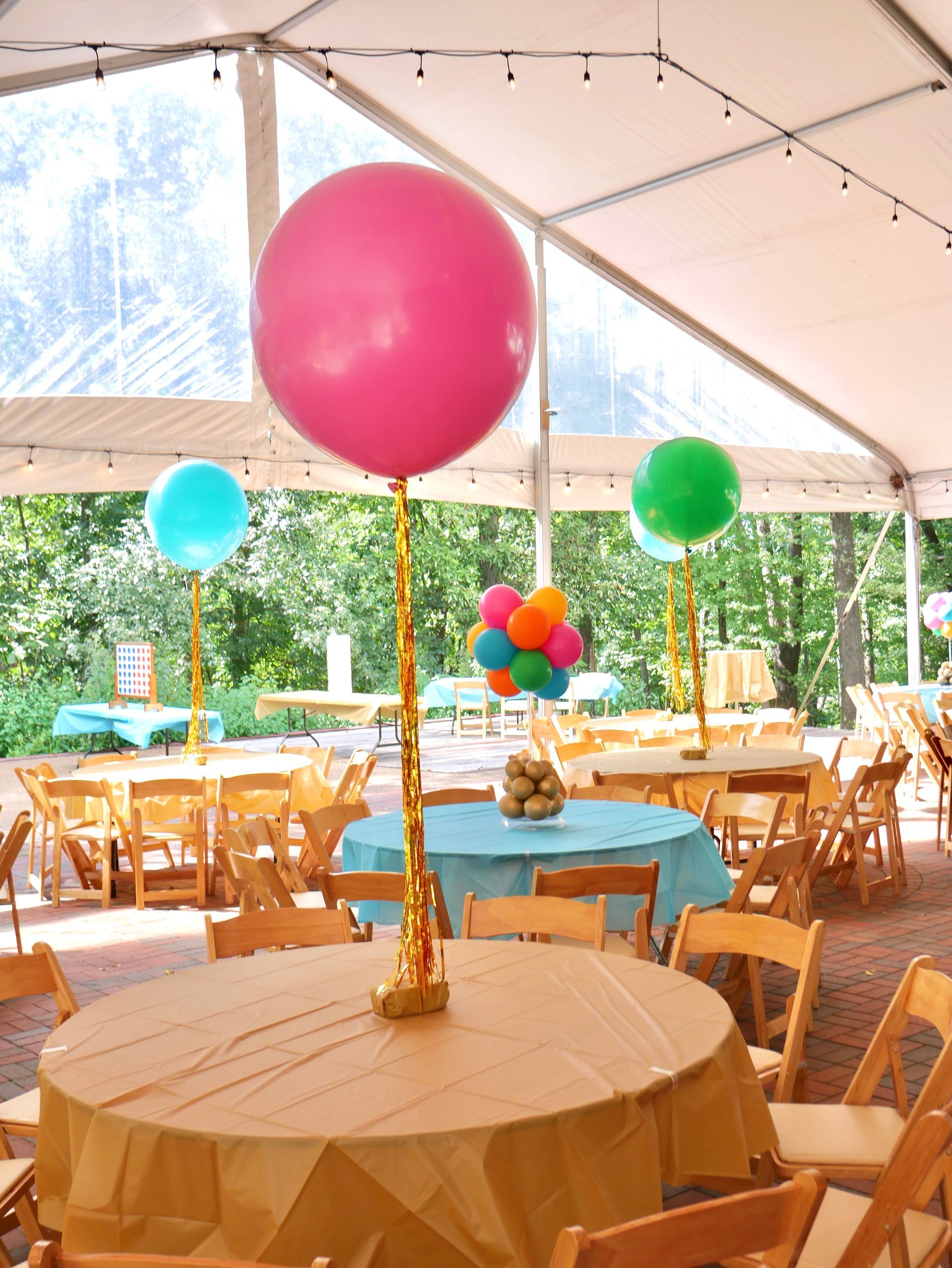 A pink balloon is sitting on top of a table in a tent