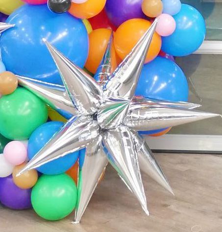 A bunch of balloons with a silver star in the middle