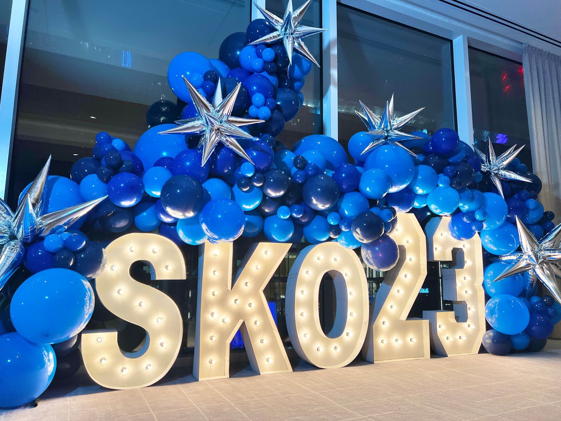 The word sko23 is surrounded by blue balloons and stars