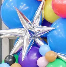 A bunch of colorful balloons with a star in the middle.