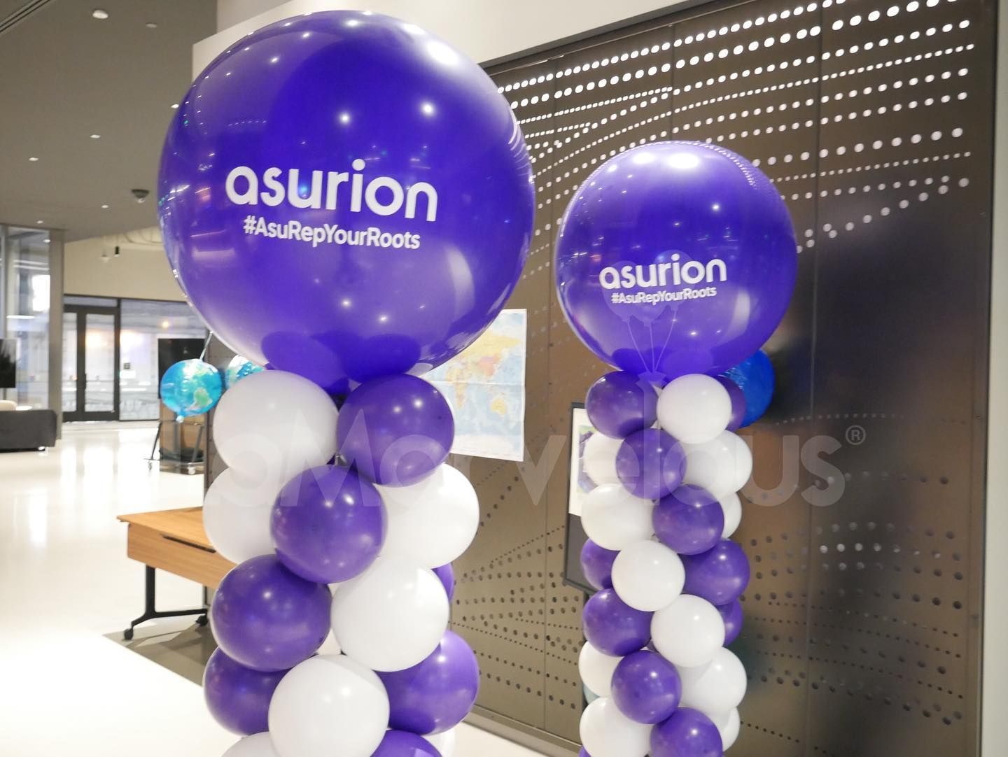 Two purple and white balloons with the word asurion on them