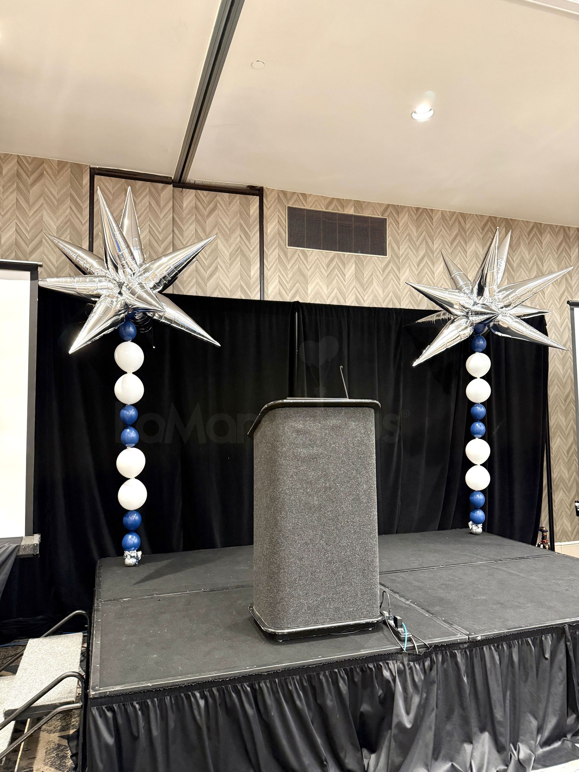 A stage with balloons in the shape of stars on it