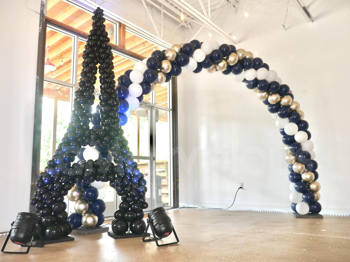 The eiffel tower is made out of balloons in a room.