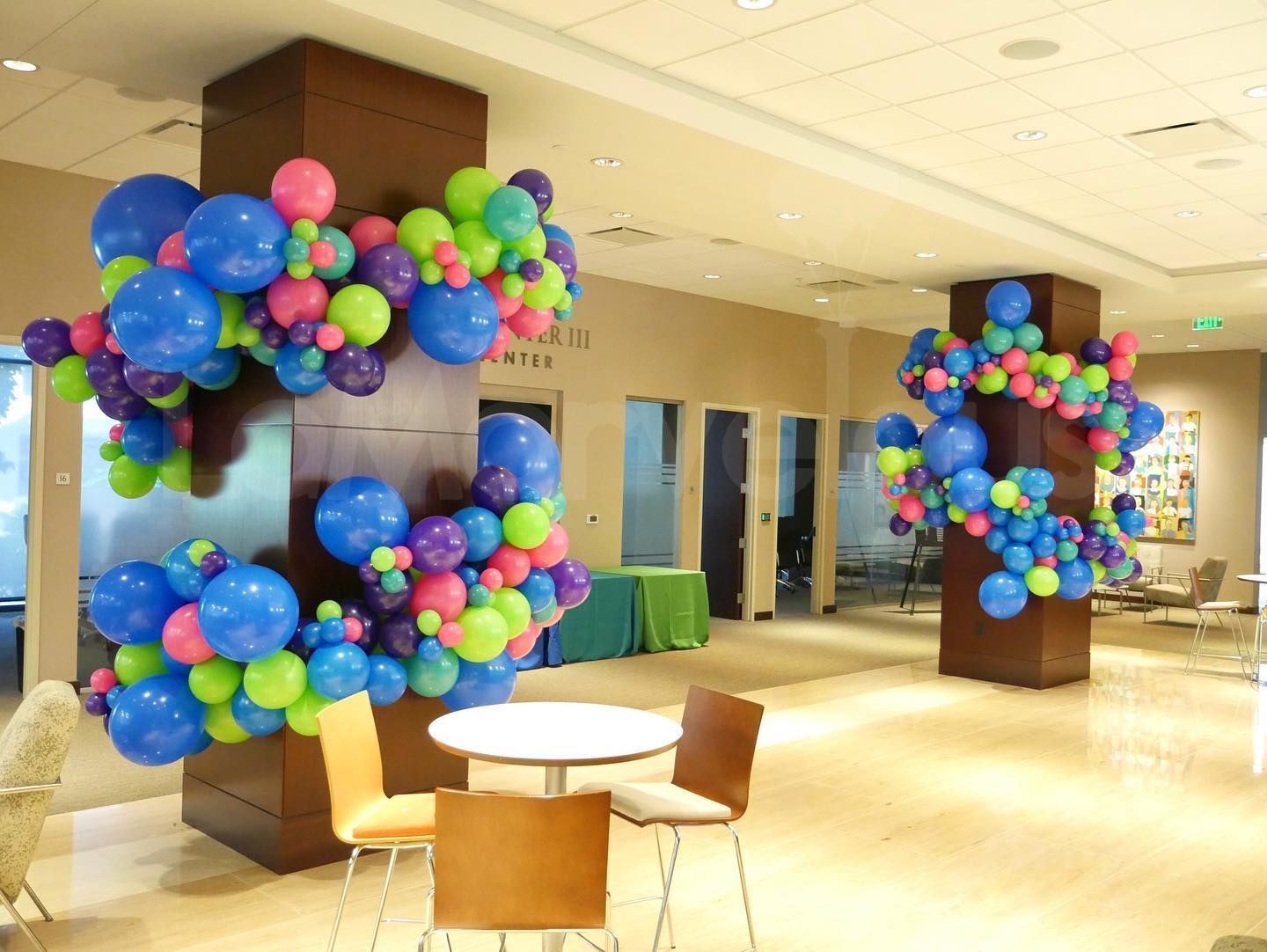 A room decorated with balloons and tables and chairs