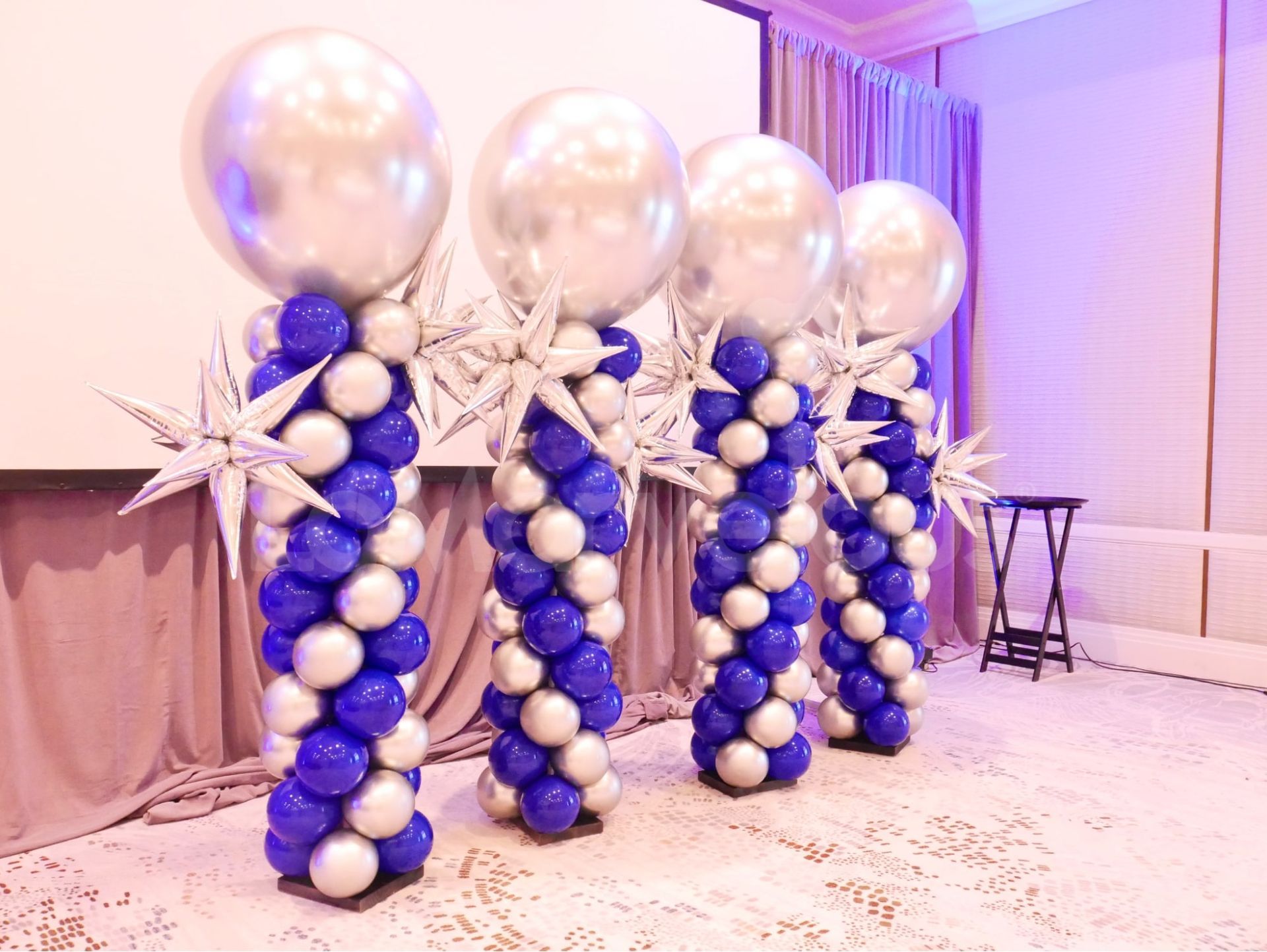 A row of blue and white balloon columns in a room.