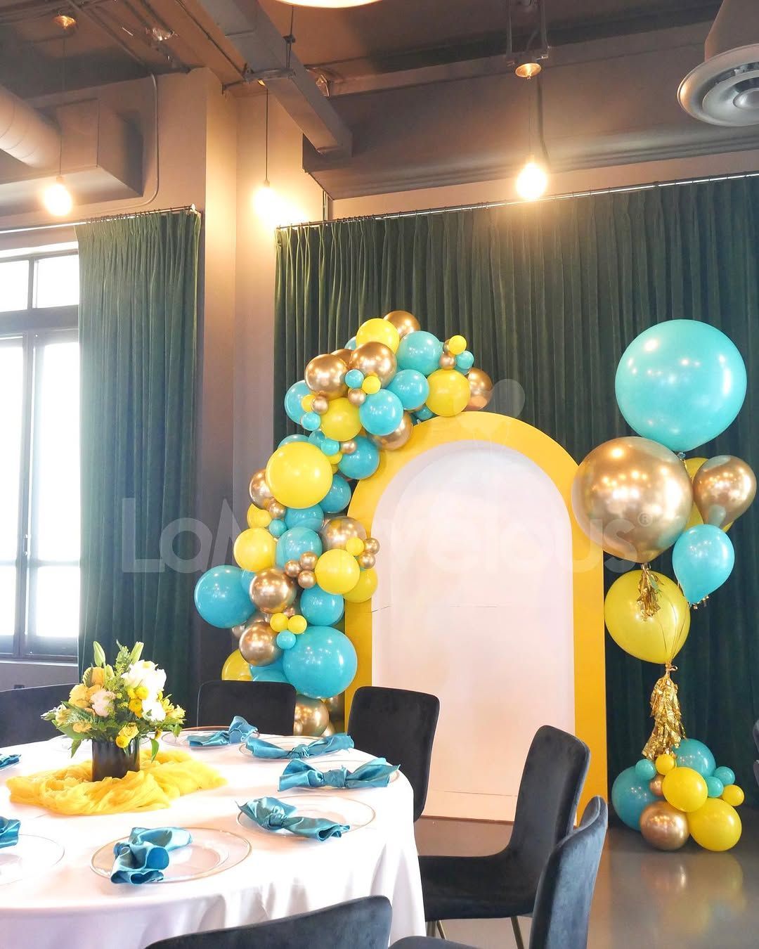 A room with tables and chairs decorated with blue and yellow balloons