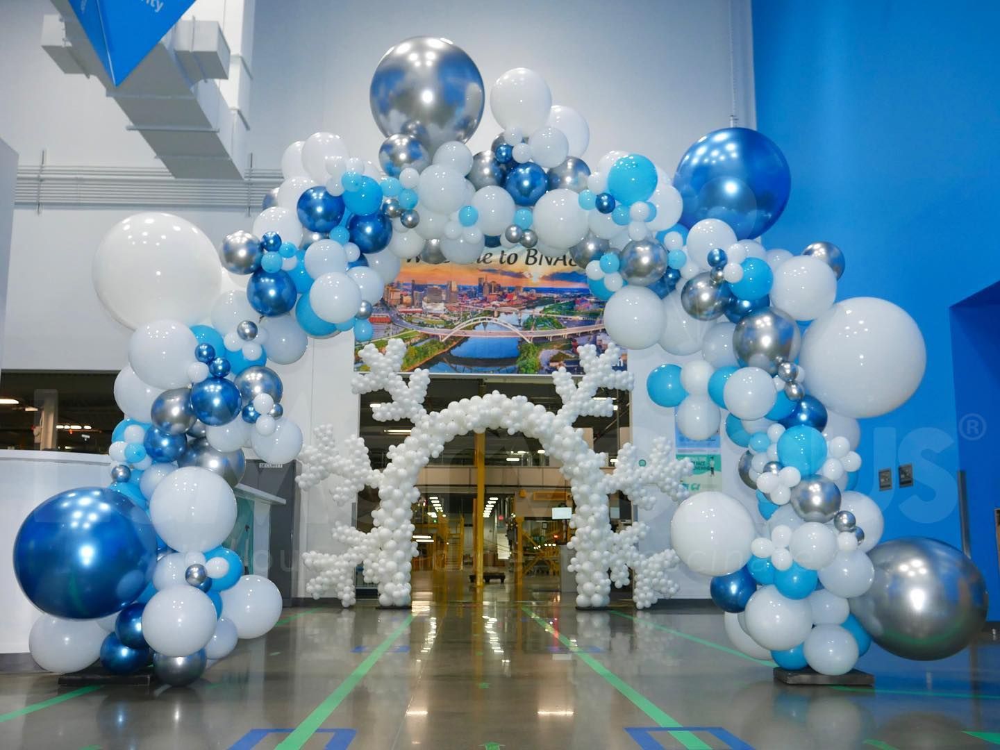 A large arch made of blue and white balloons and snowflakes.