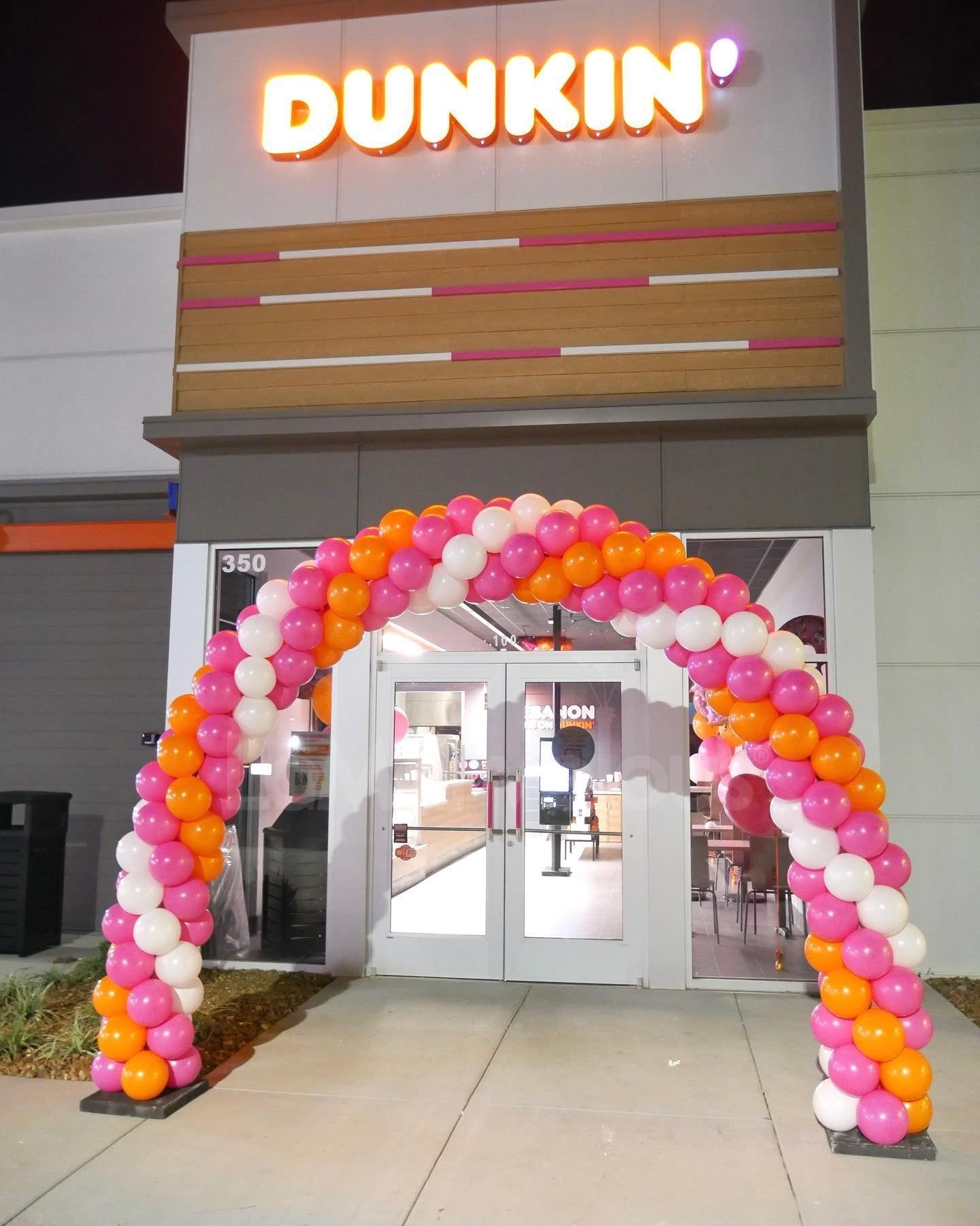 A dunkin ' donuts store with balloons in front of it