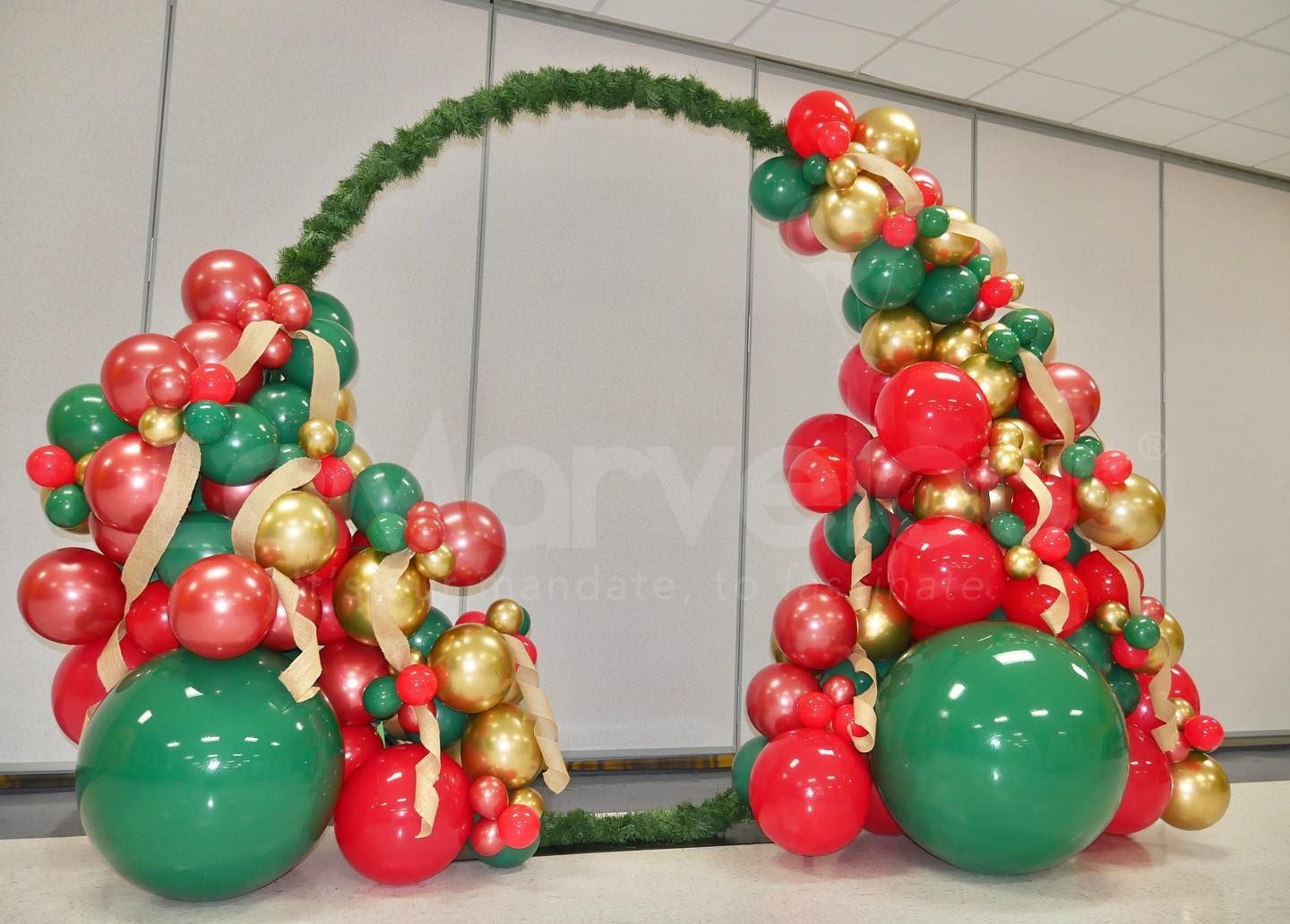 A christmas tree made of red , green and gold balloons