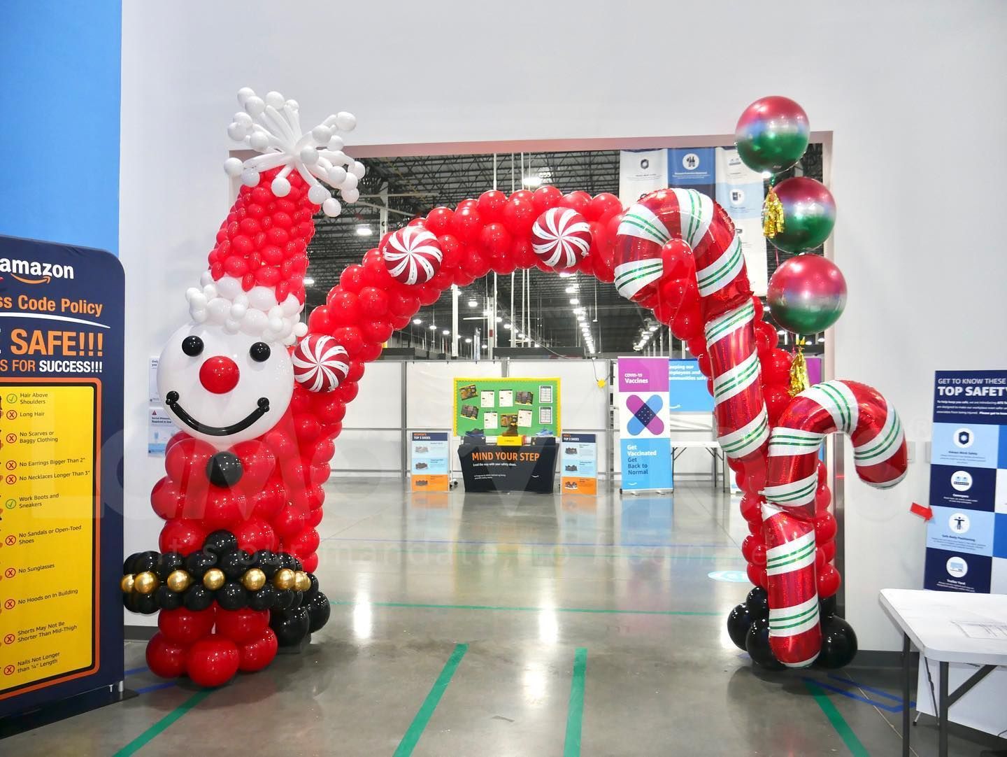 A balloon arch with a santa claus and candy canes made of balloons.