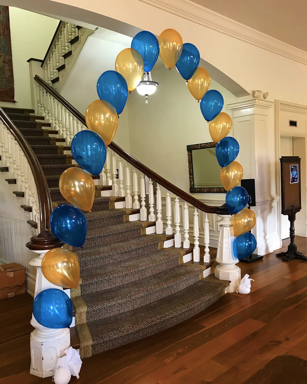 A staircase decorated with blue and gold balloons