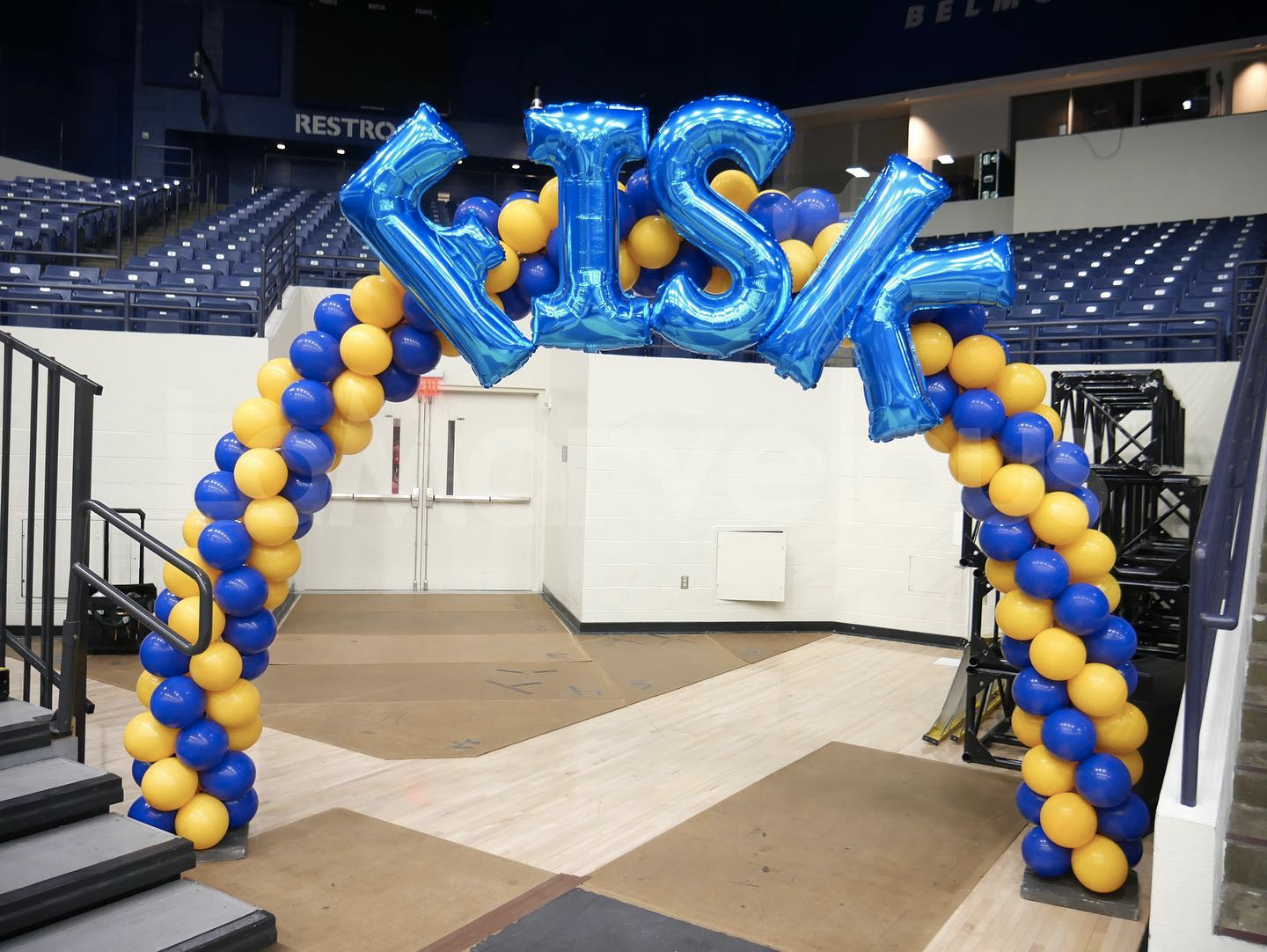 A blue and yellow balloon arch with the word district on it
