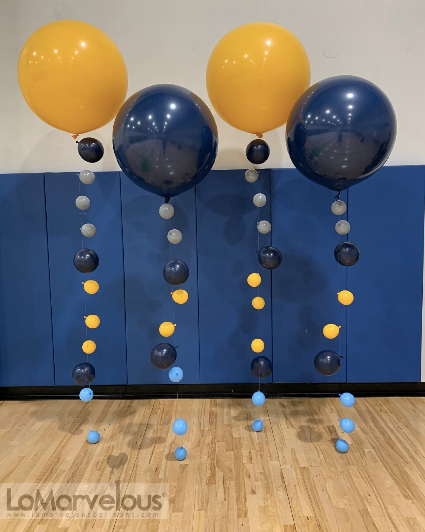 A bunch of balloons are hanging from a wall