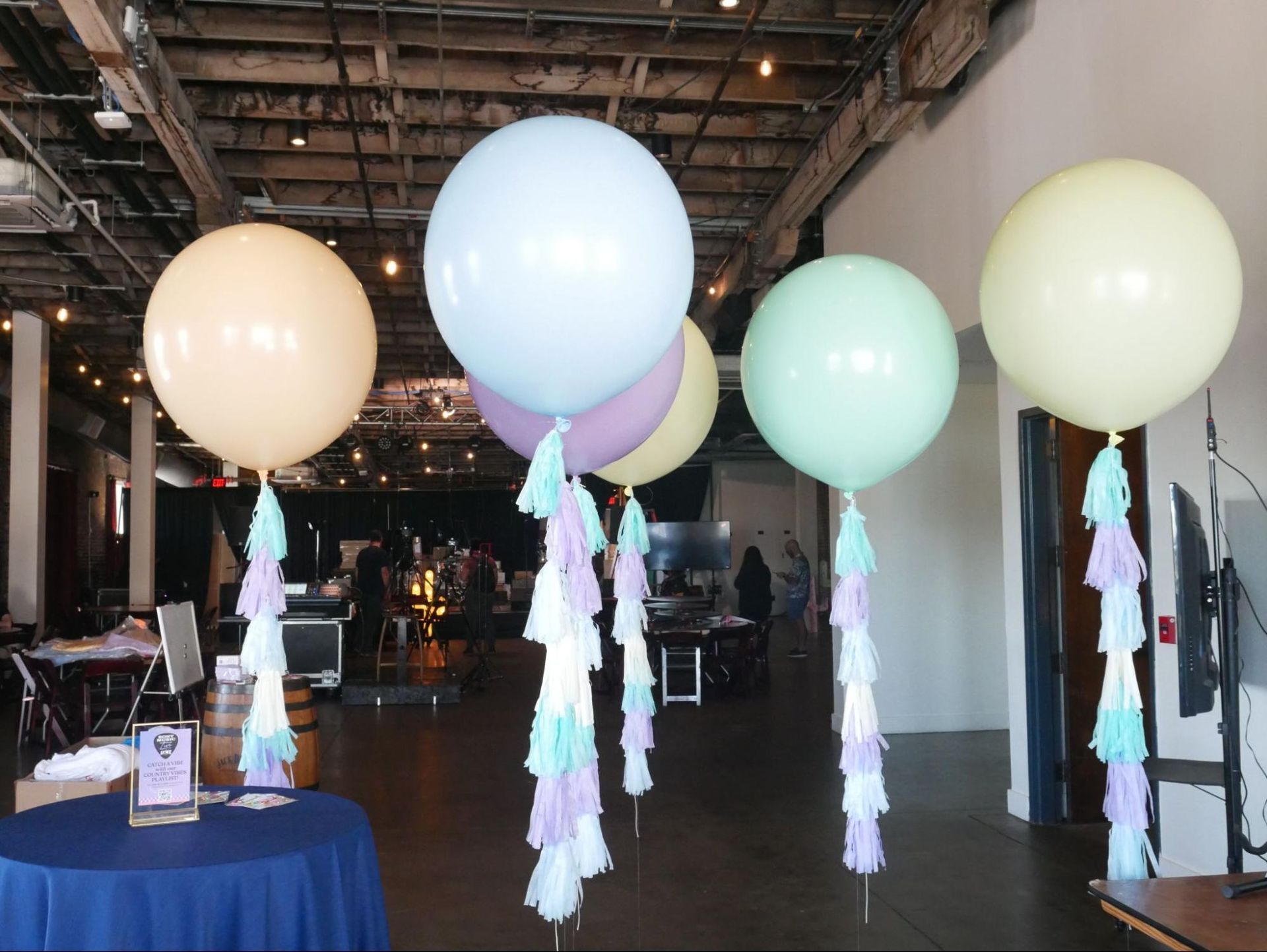 A bunch of balloons with tassels hanging from them in a room