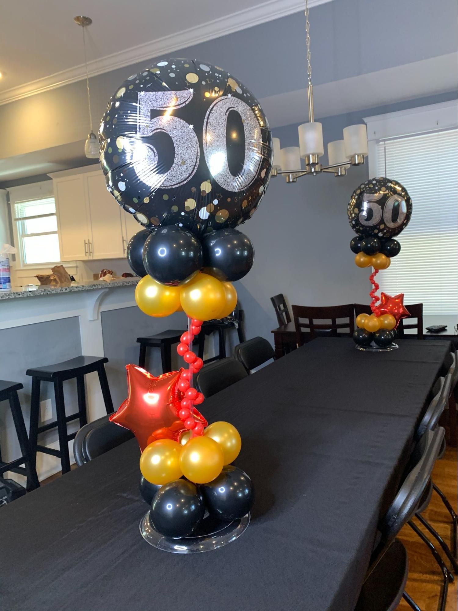 A table topped with balloons and a balloon with the number 50 on it.