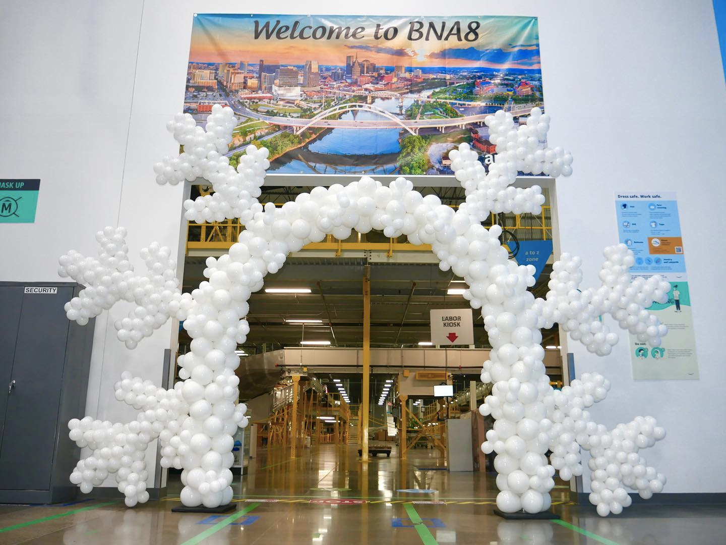 A large arch made of white balloons in the shape of snowflakes