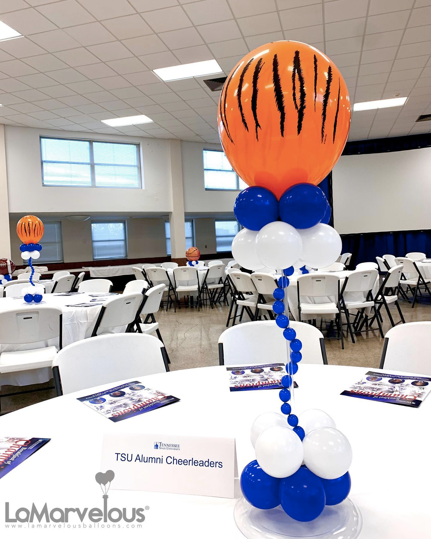 A basketball is sitting on top of a bunch of balloons on a table.
