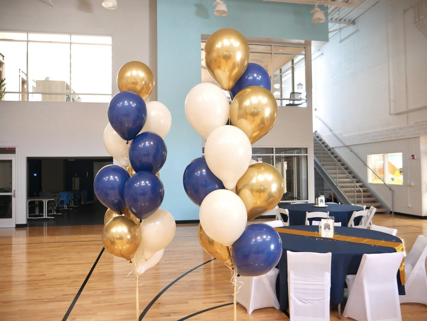 A bunch of balloons in a room with tables and chairs