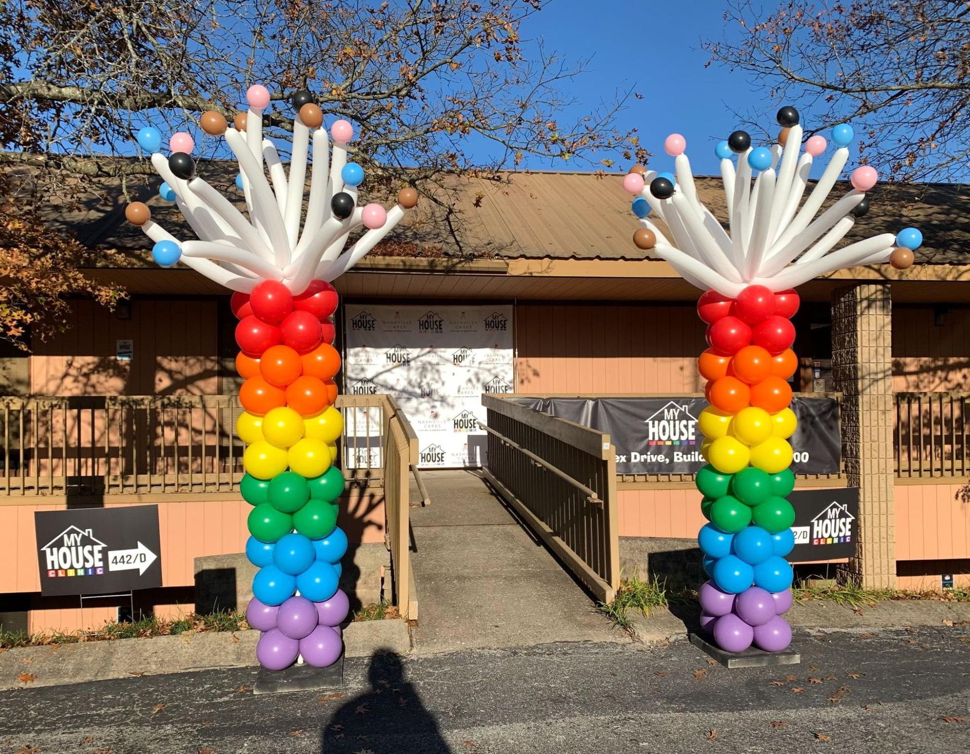 A rainbow colored balloon display in front of a building