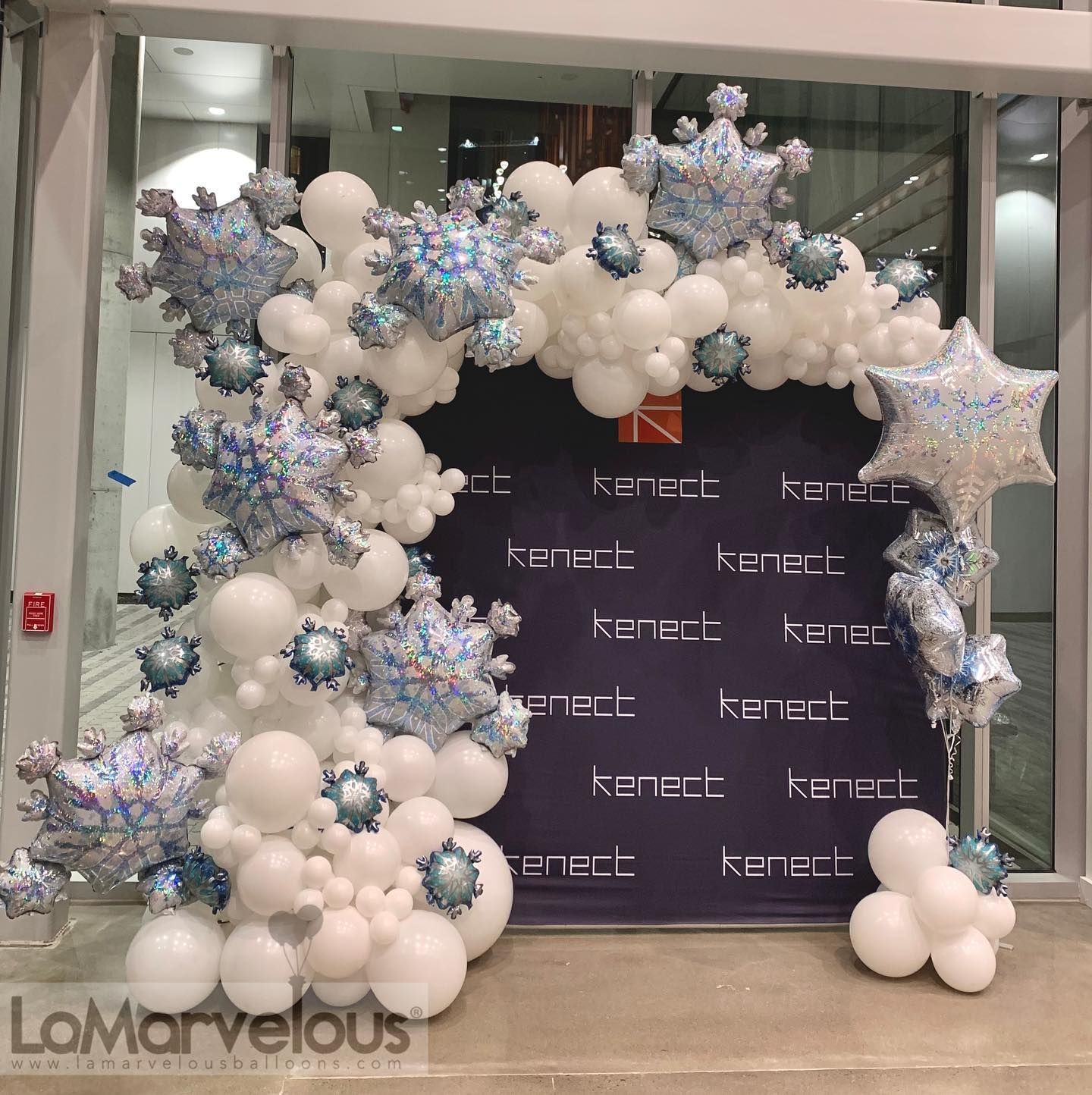 A display of balloons and snowflakes in front of a sign that says lomarvelous