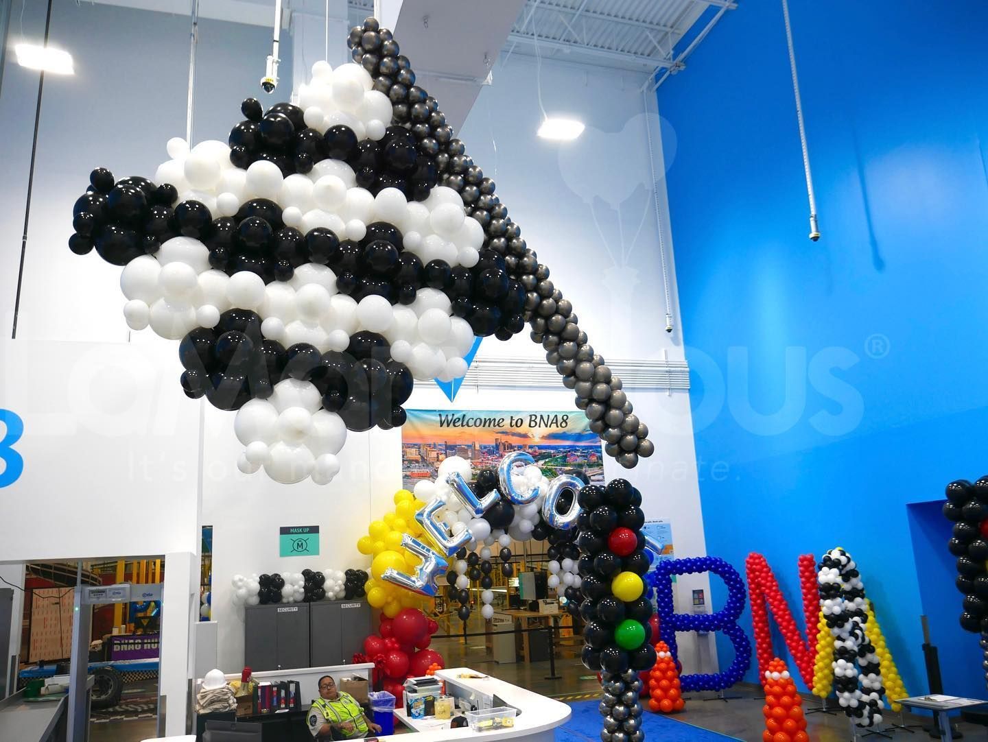 A room filled with balloons and a sign that says bna