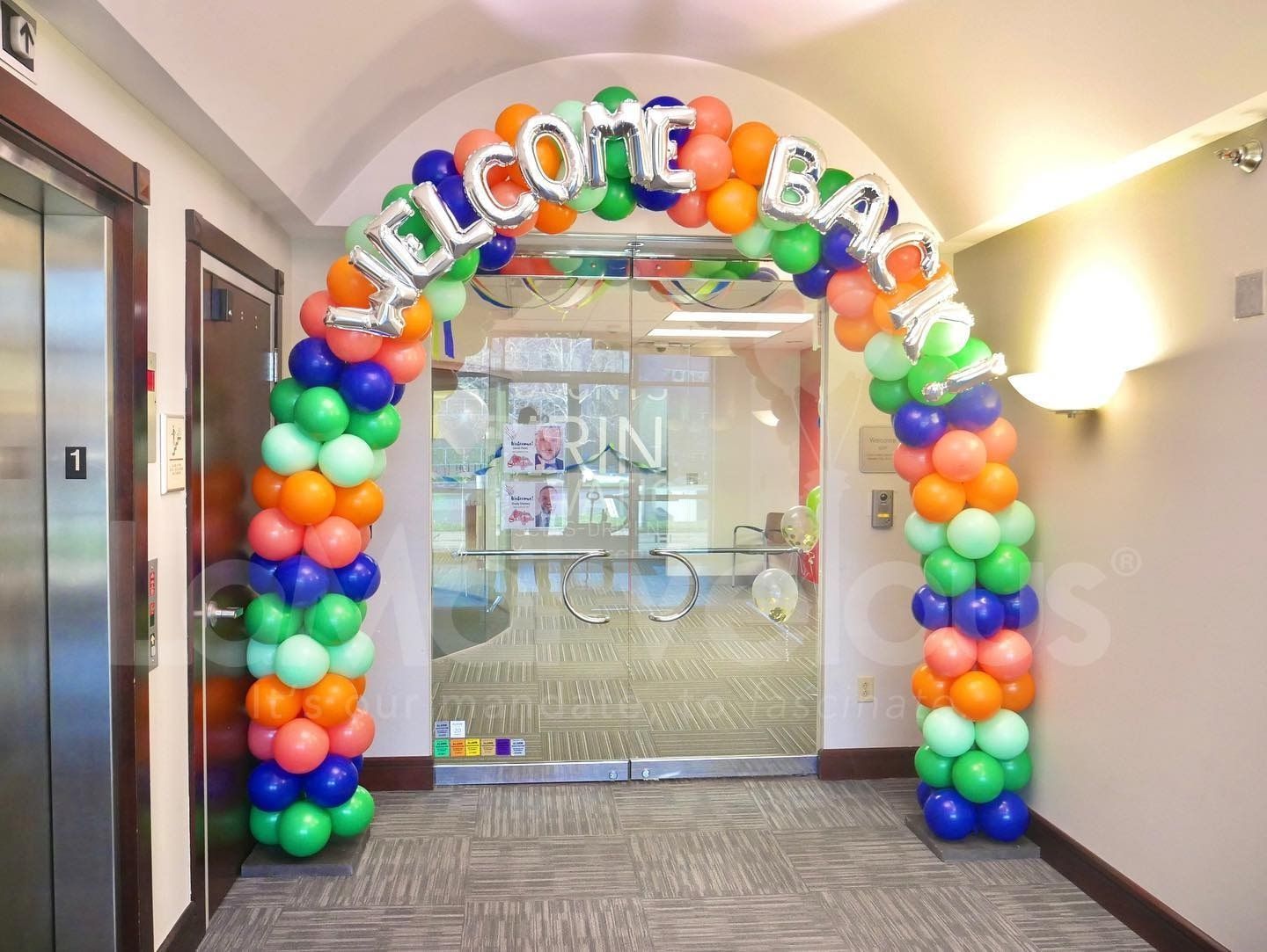A hallway with balloons and a welcome sign