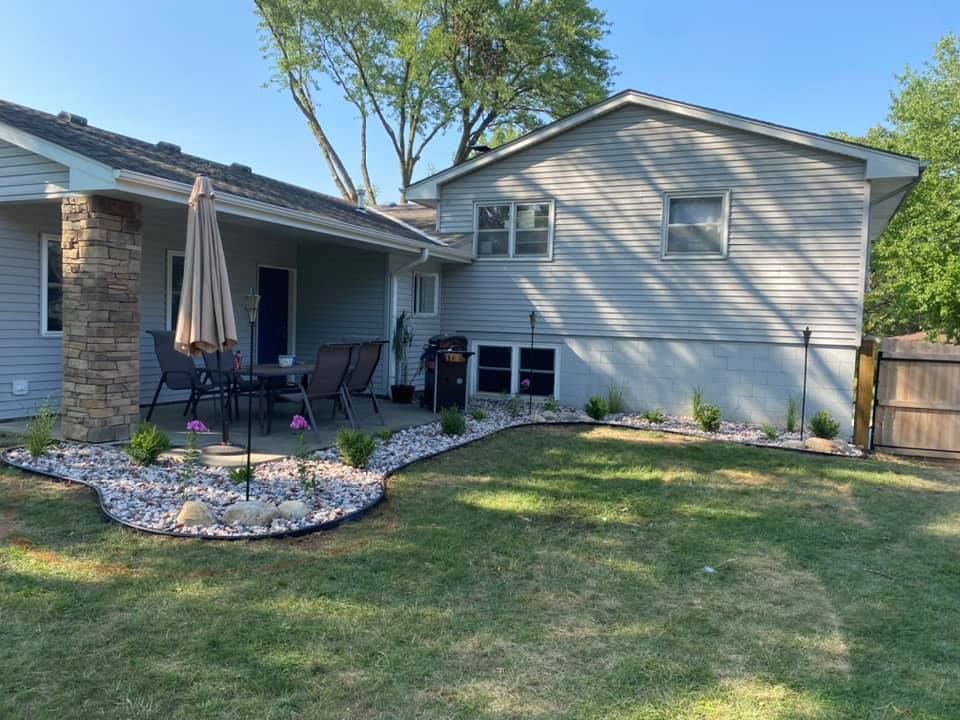 A house with a patio and umbrella in front of it.