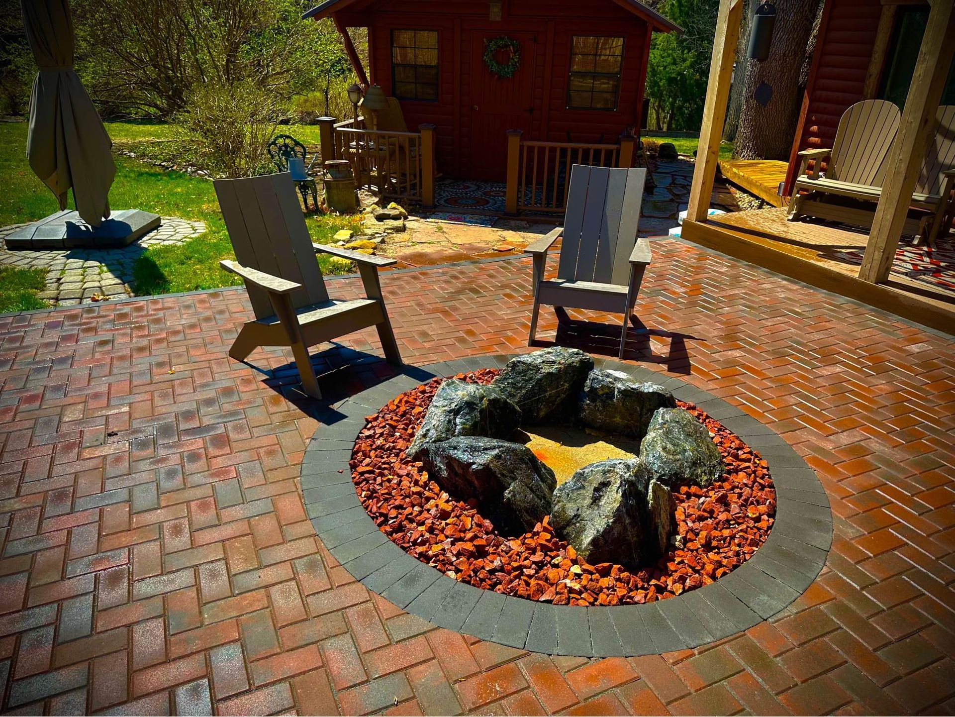 There is a fire pit on the patio with chairs around it.