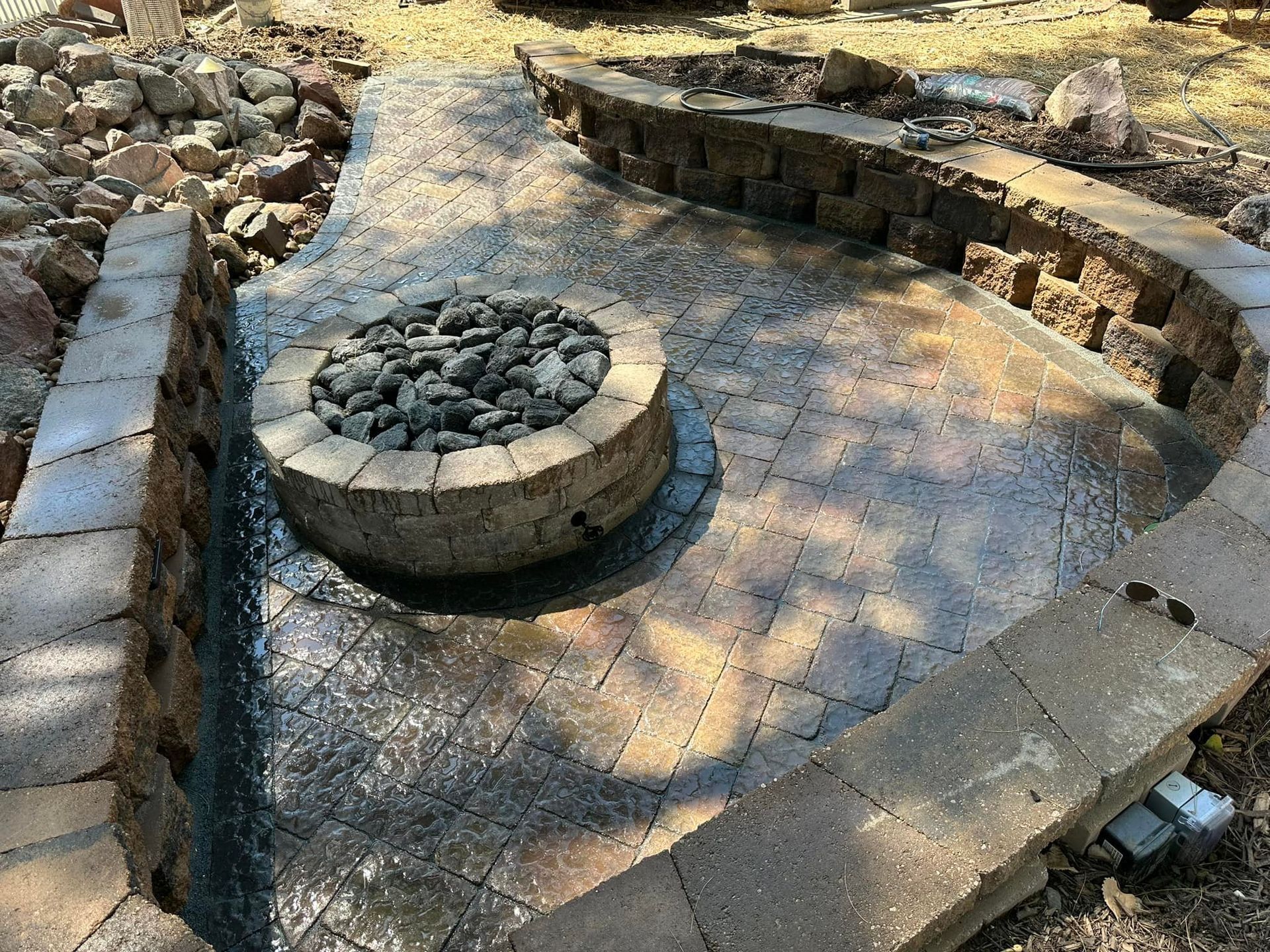A fire pit is sitting on top of a brick patio.