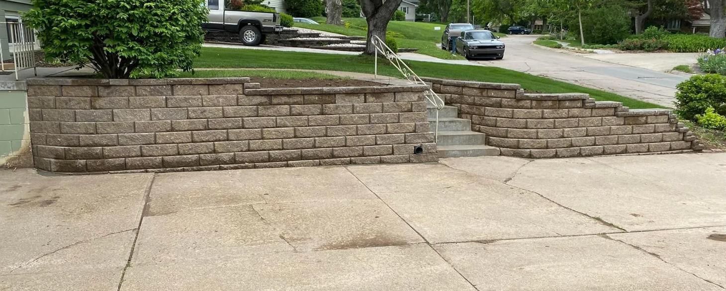 A brick wall with stairs leading up to it in a driveway.