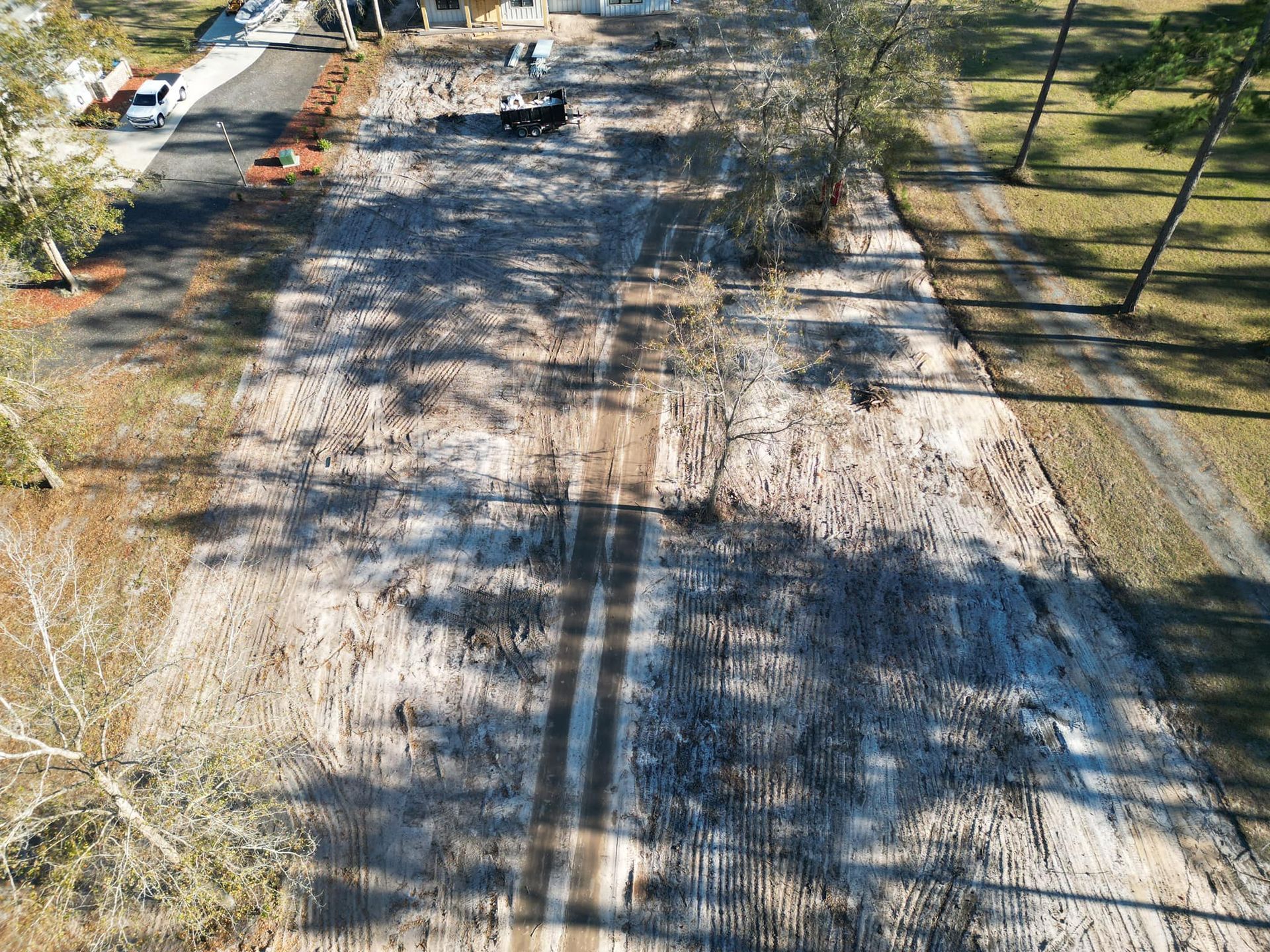 An aerial view of a dirt road surrounded by trees.