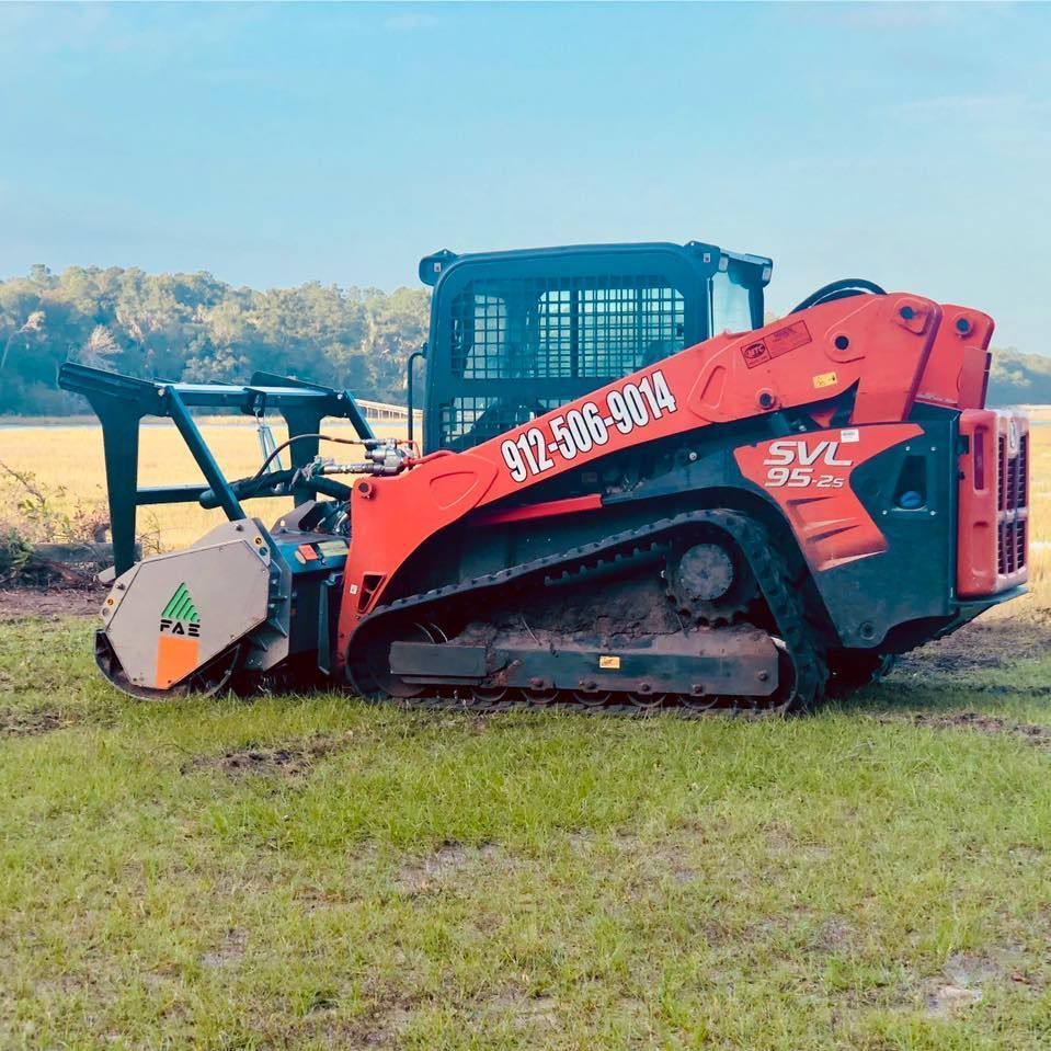 A red and black tractor is parked in a grassy field.