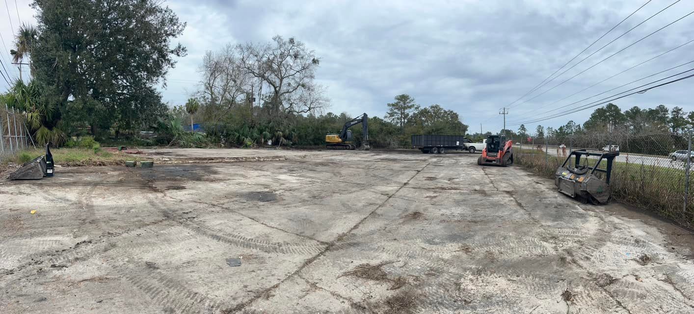 A large dirt field with a bulldozer in the middle of it.