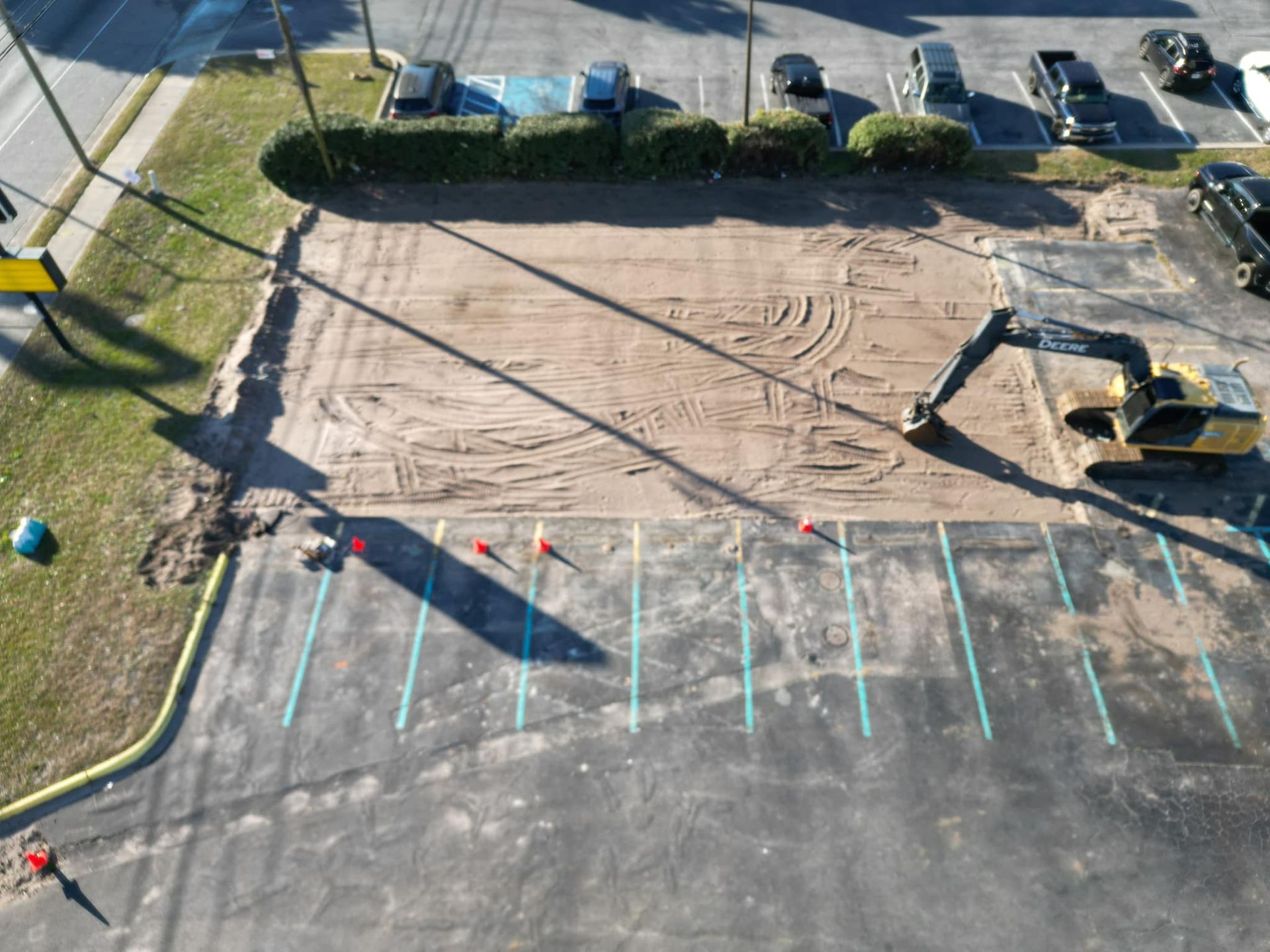 An aerial view of a parking lot with a bulldozer moving dirt