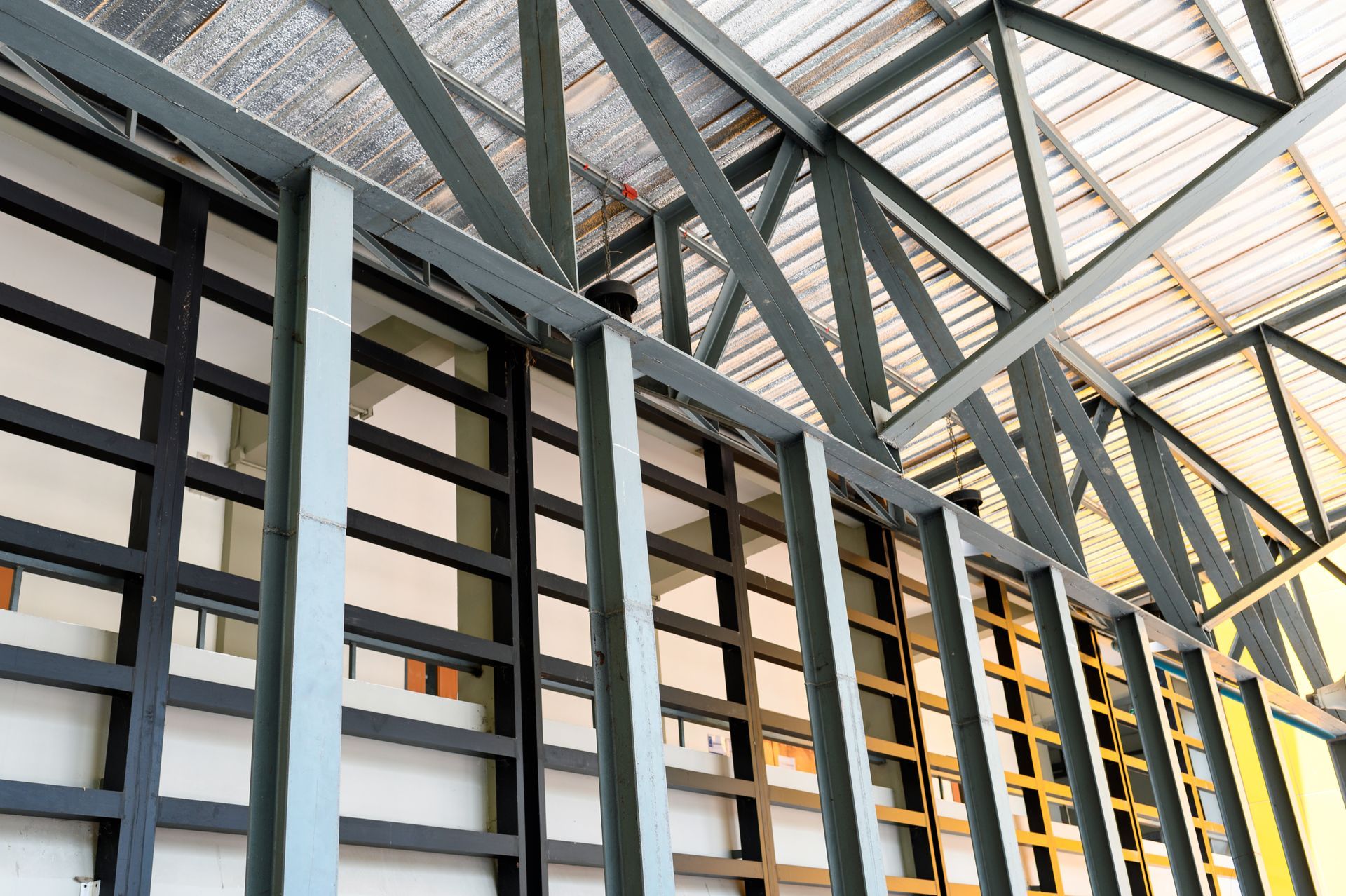 Steel framework for a building's roof and walls, with visible insulation and window frames.