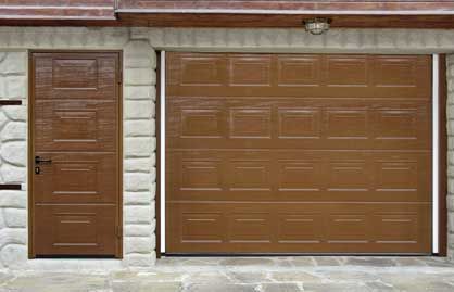 Una puerta de garaje con una puerta de madera al lado.