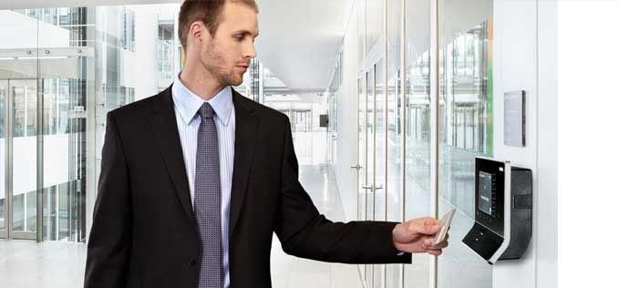 Un hombre con traje y corbata utiliza una tarjeta inteligente para acceder a una puerta.