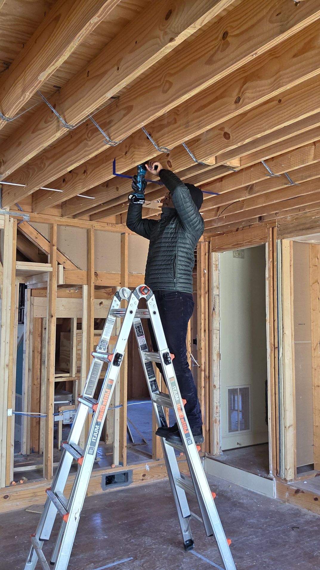 Woman in straw hat smiles, holding wine glass near a lake.