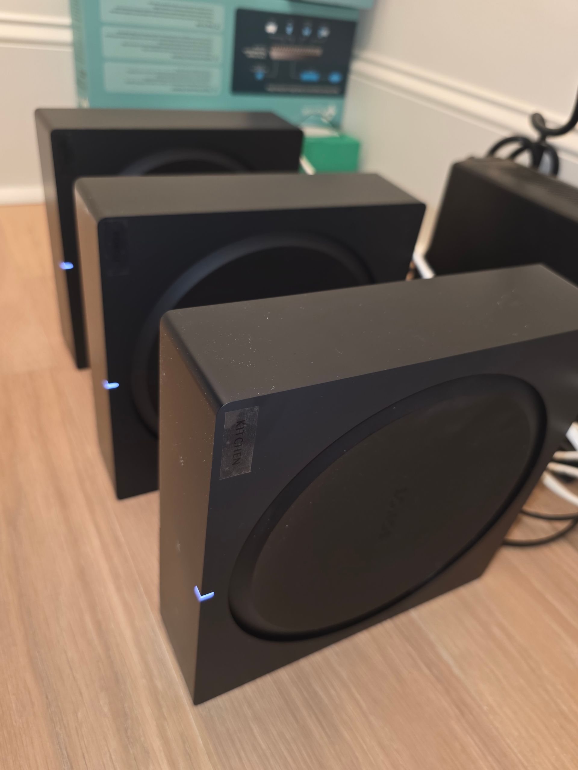 Woman in straw hat smiles, holding wine glass near a lake.