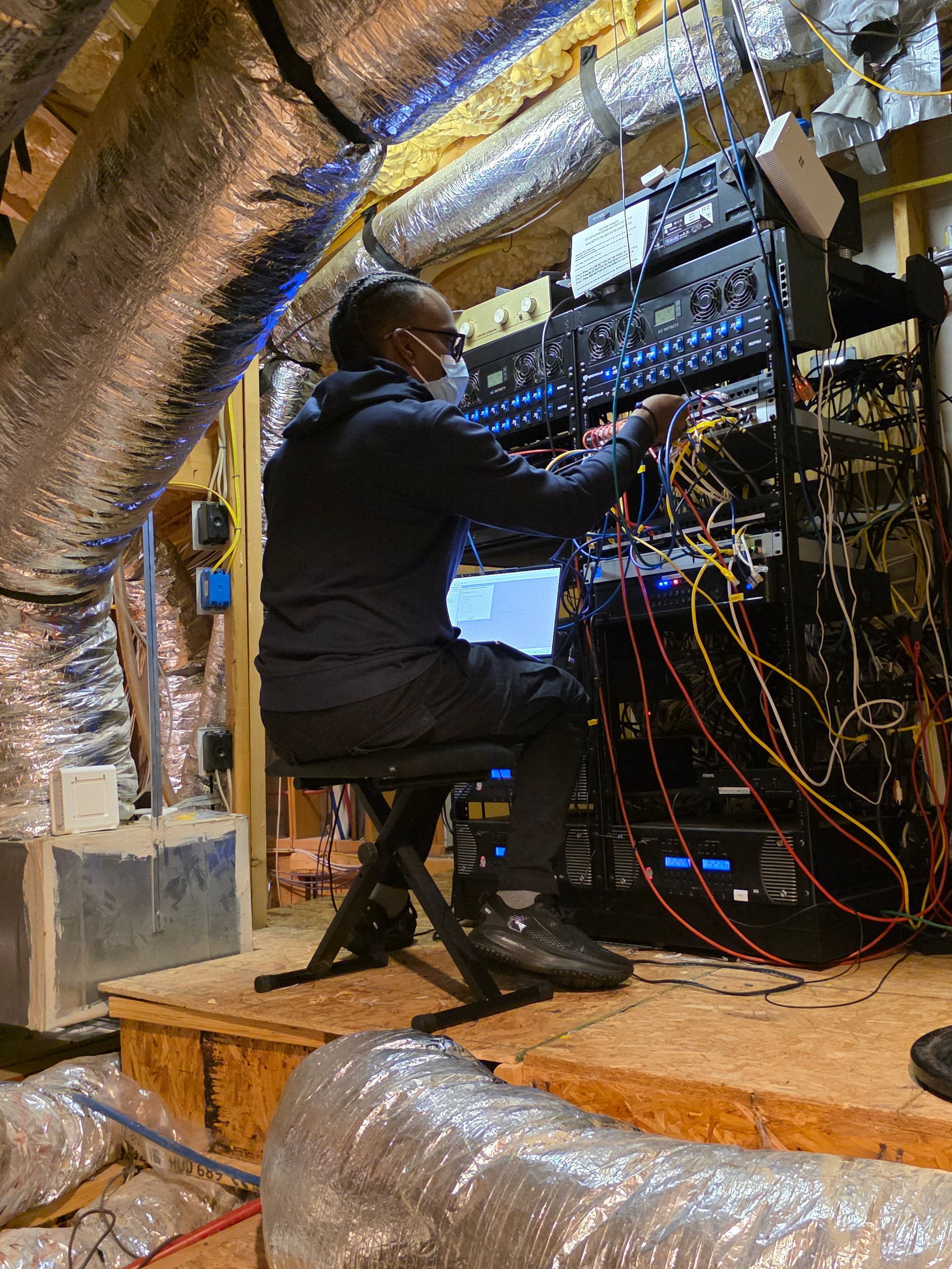 Woman in straw hat smiles, holding wine glass near a lake.