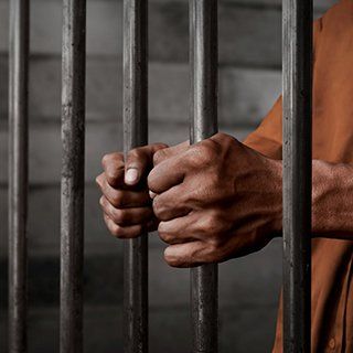 Bail Bond Company — Prisoner Behind The Cell in Birmingham, AL