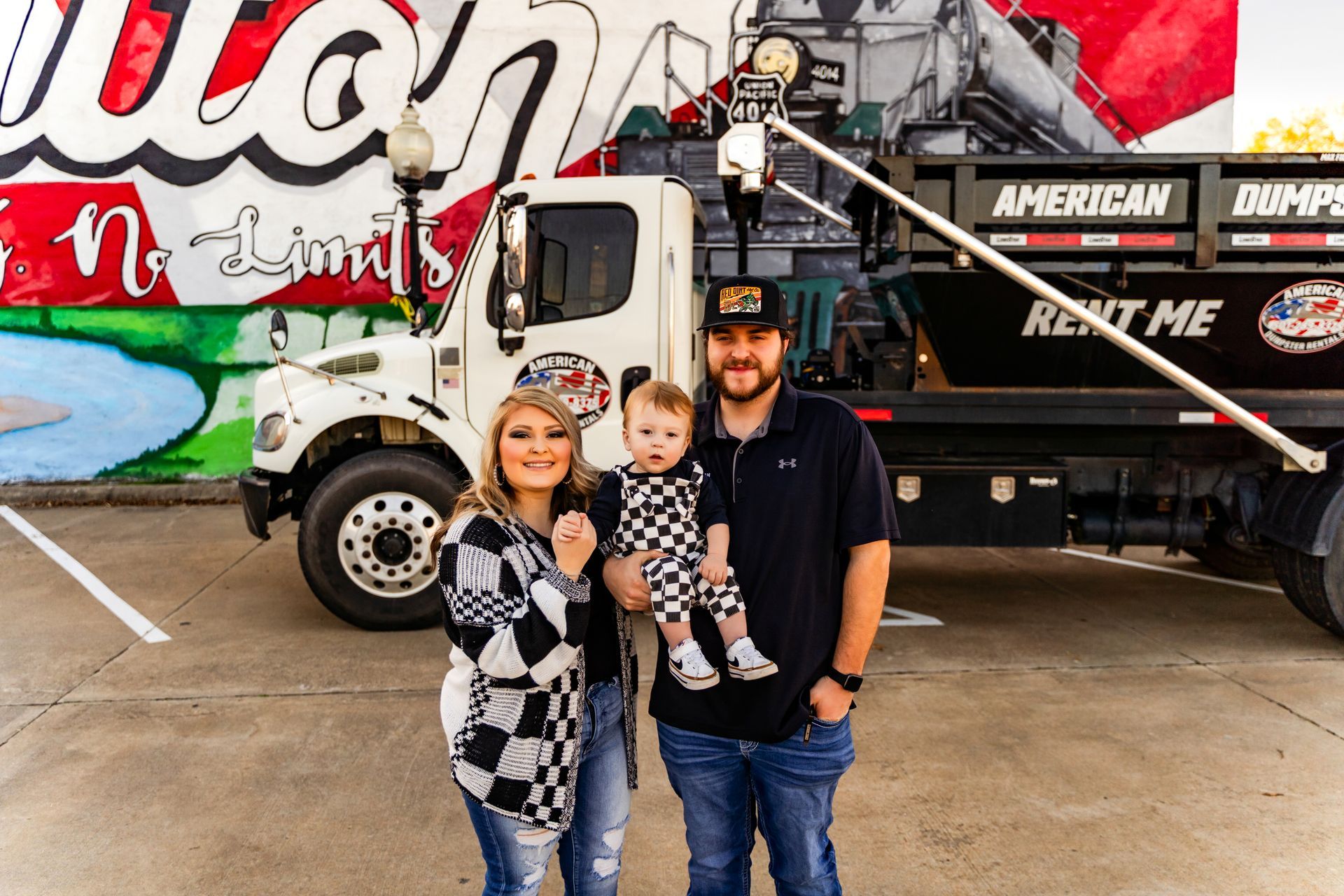 A man is standing next to a white truck in a field.