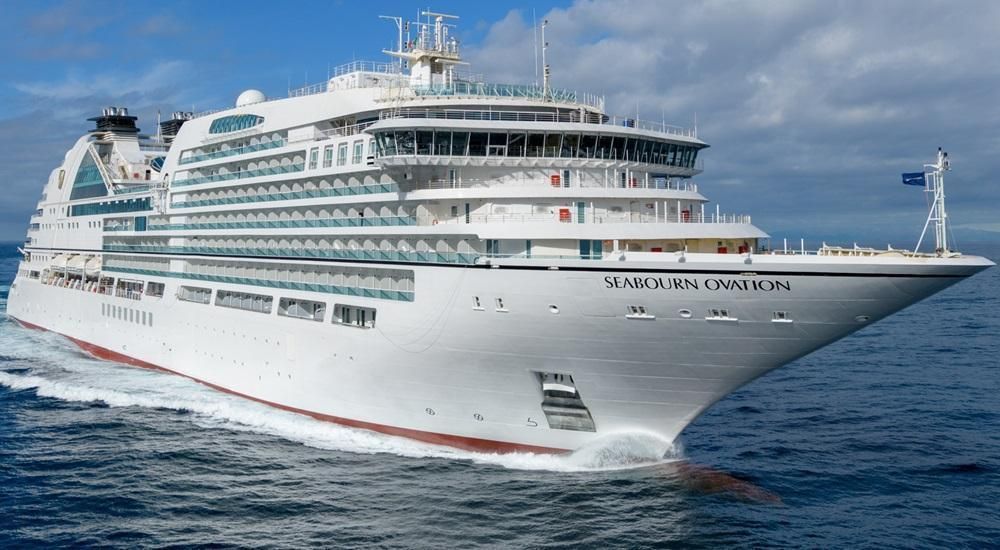 A large white cruise ship is floating on top of a body of water.
