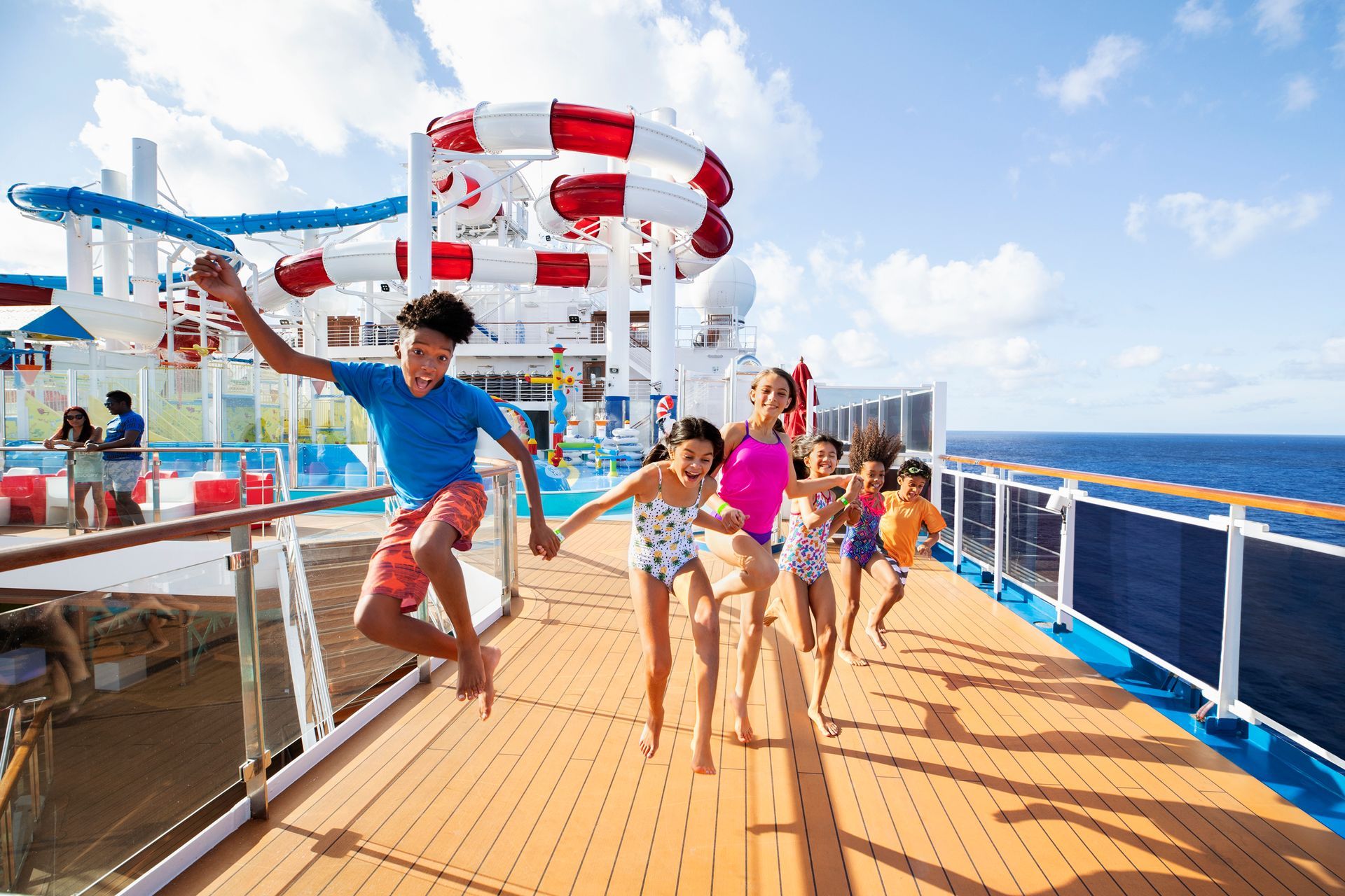 A group of children are jumping in the air on a cruise ship.