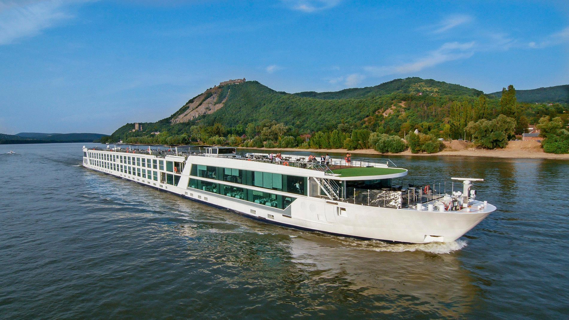 A large white cruise ship is floating on top of a large body of water.
