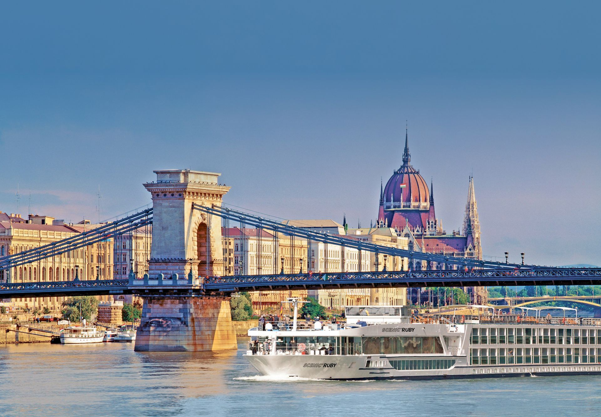 A boat is going under a bridge over a river.