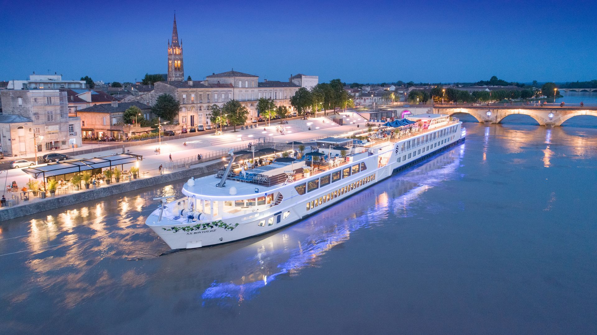 A large cruise ship is floating on top of a river.